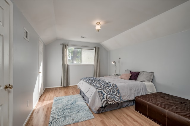 bedroom featuring lofted ceiling and light wood-type flooring