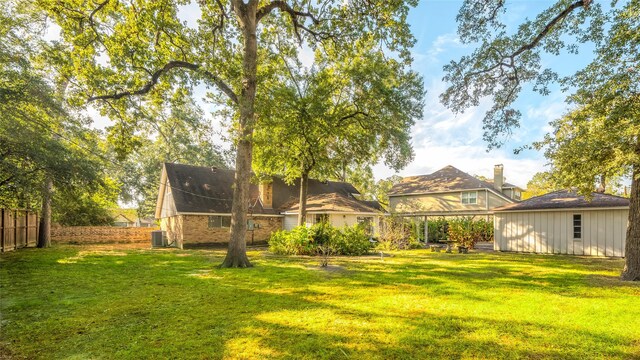 back of property with a yard and central AC unit