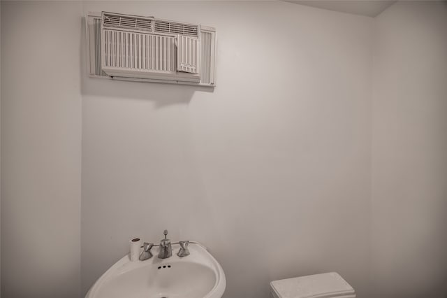 bathroom featuring a wall unit AC and sink