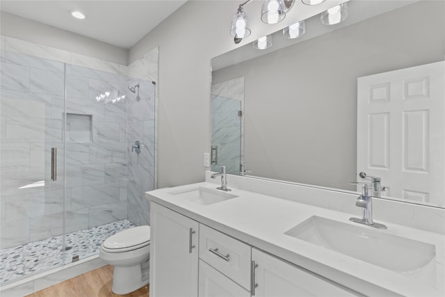 bathroom with toilet, hardwood / wood-style floors, walk in shower, and vanity