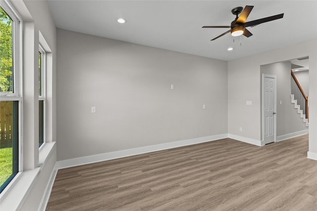 spare room featuring a wealth of natural light, light hardwood / wood-style floors, and ceiling fan