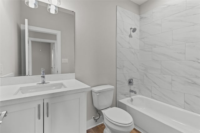 full bathroom featuring vanity, tiled shower / bath combo, wood-type flooring, and toilet