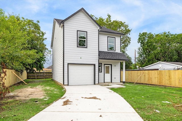 view of front of home featuring a front yard and a garage