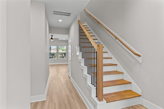 stairway with ceiling fan and hardwood / wood-style flooring