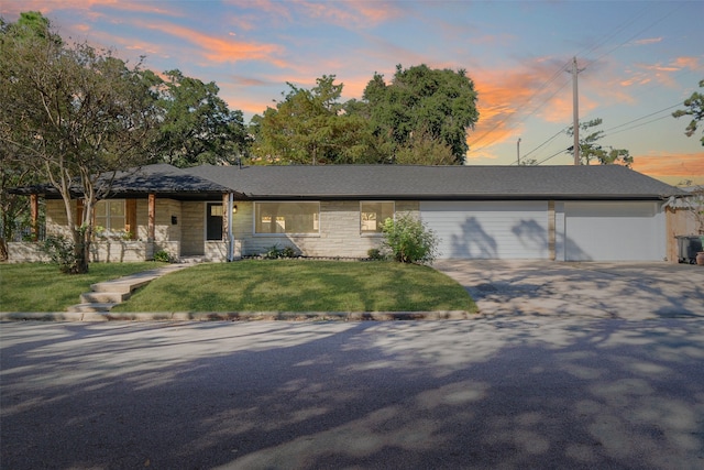 view of front of house featuring a garage and a lawn