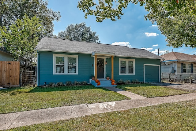 ranch-style house featuring a garage and a front lawn