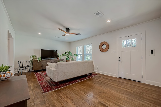 living room featuring ornamental molding, wood-type flooring, and ceiling fan