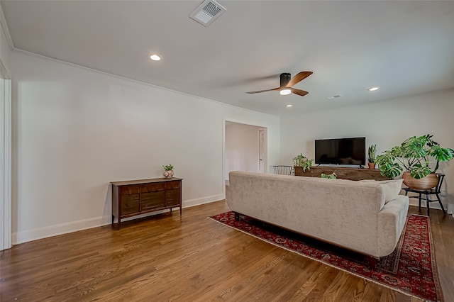 living room featuring ceiling fan, wood-type flooring, and ornamental molding