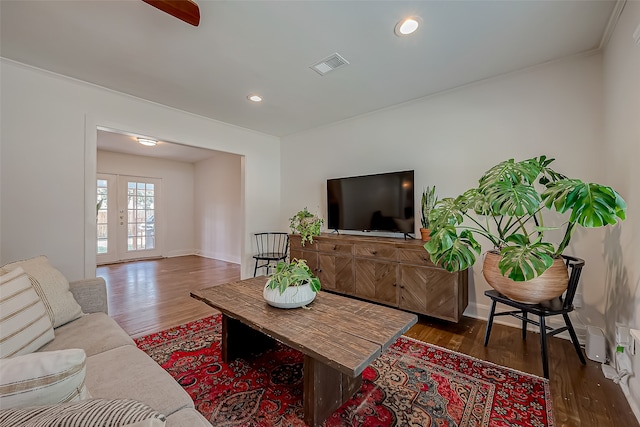 living room featuring crown molding and dark hardwood / wood-style flooring