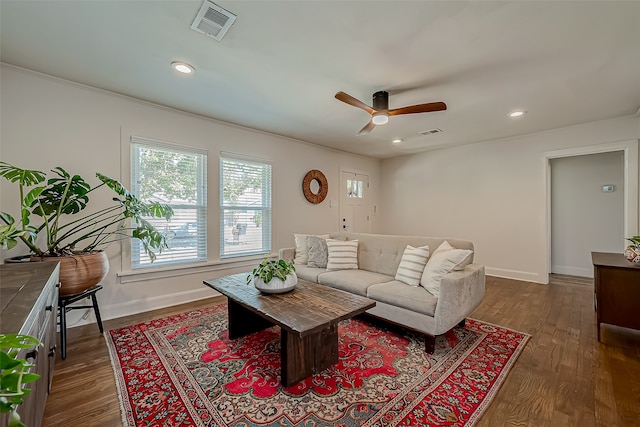 living room featuring crown molding, dark hardwood / wood-style floors, and ceiling fan