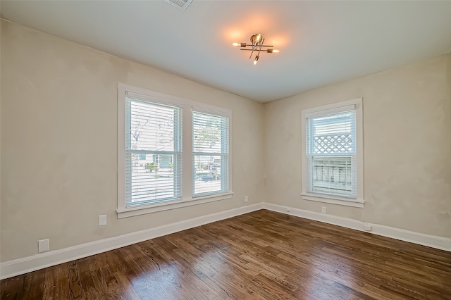 unfurnished room featuring dark hardwood / wood-style flooring and a wealth of natural light