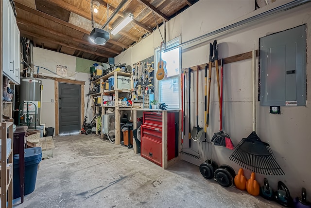 garage featuring a garage door opener, a workshop area, electric panel, and gas water heater