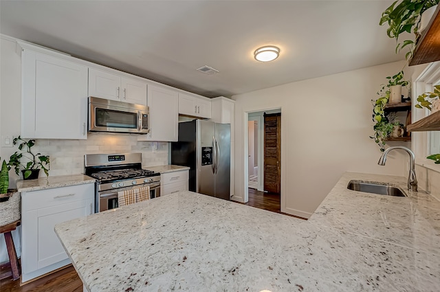 kitchen featuring light stone counters, white cabinetry, dark hardwood / wood-style floors, sink, and stainless steel appliances