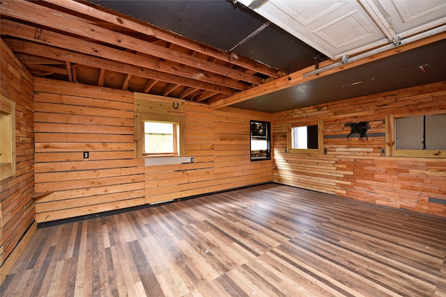 spare room with wood-type flooring and wooden walls