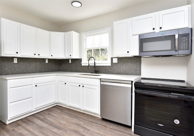 kitchen featuring white cabinets, backsplash, wood-type flooring, sink, and stainless steel appliances