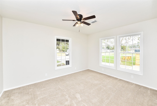 spare room featuring light carpet and ceiling fan