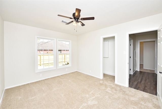 unfurnished bedroom with a closet, ceiling fan, and light carpet