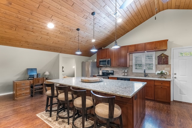 kitchen with a center island, hanging light fixtures, stainless steel appliances, high vaulted ceiling, and dark hardwood / wood-style floors