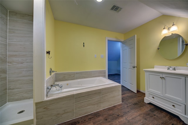 bathroom featuring vanity, hardwood / wood-style floors, vaulted ceiling, and plus walk in shower