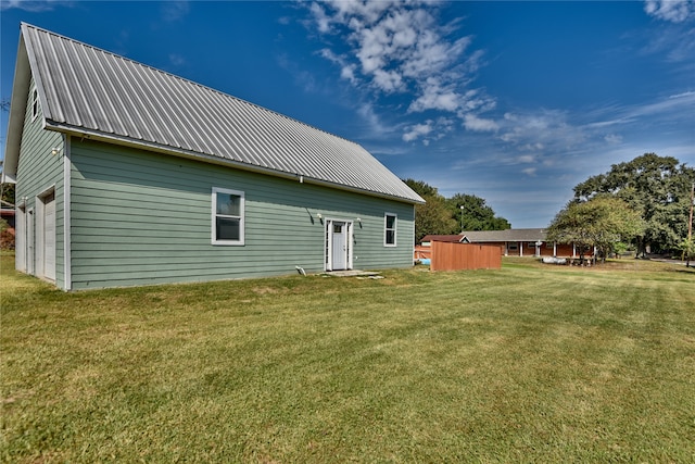 rear view of house featuring a shed and a lawn