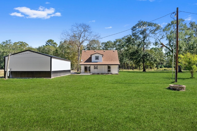 back of property with an outdoor structure and a lawn