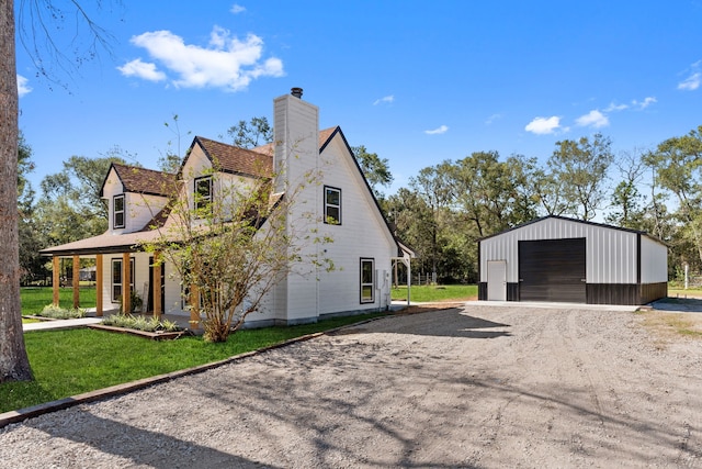 view of side of property with a yard, an outdoor structure, and a garage