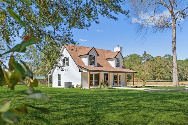 rear view of property with a yard and central AC