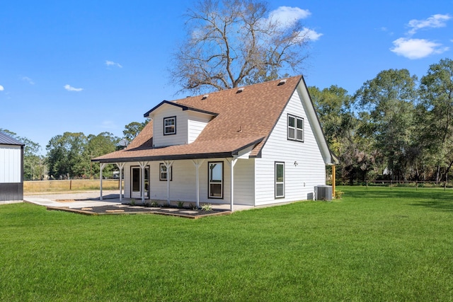 rear view of property with a yard and central AC unit