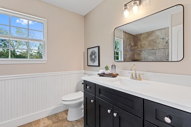 bathroom with vanity, toilet, and a tile shower