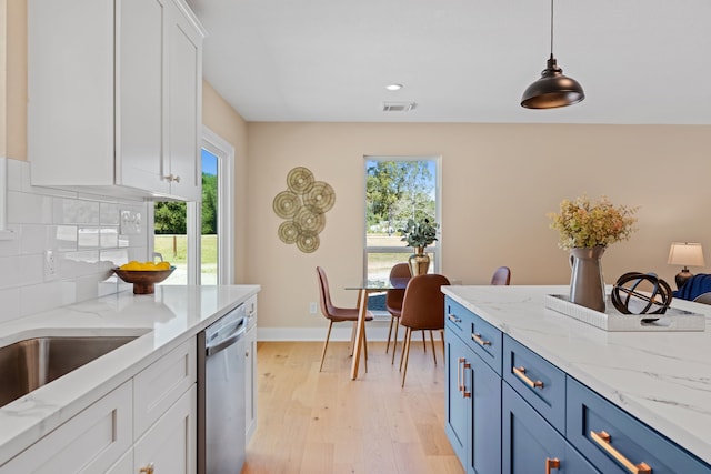 kitchen with dishwasher, hanging light fixtures, blue cabinetry, white cabinets, and light hardwood / wood-style floors