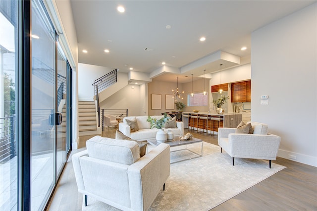 living room with a notable chandelier, hardwood / wood-style flooring, and a healthy amount of sunlight