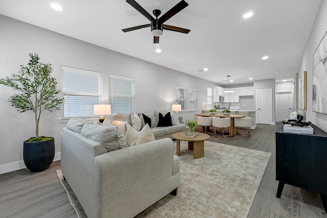 living room with ceiling fan and light wood-type flooring