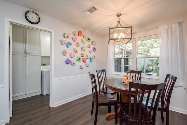 dining room featuring dark hardwood / wood-style flooring, washer / clothes dryer, and a notable chandelier