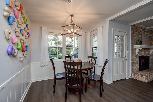 dining room featuring an inviting chandelier, dark wood-type flooring, and a brick fireplace