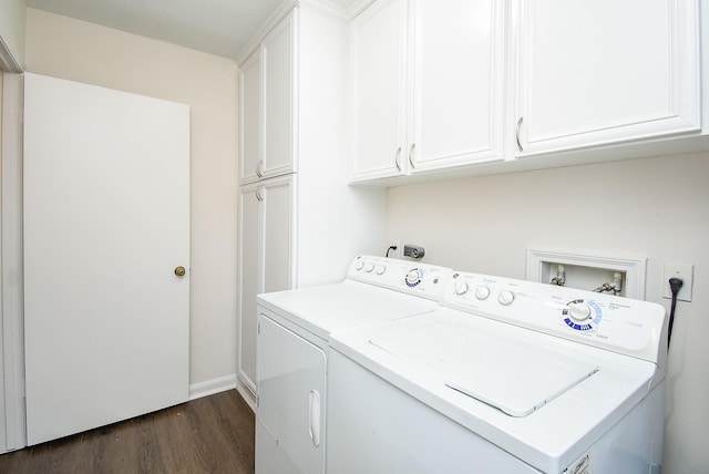 clothes washing area featuring washer and dryer, dark hardwood / wood-style floors, and cabinets