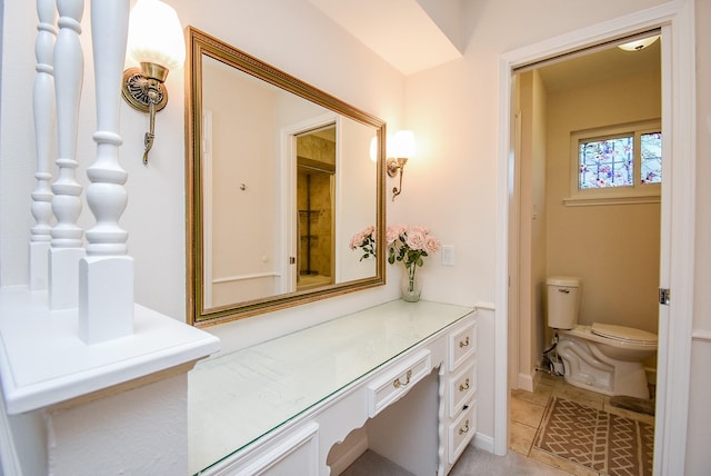 bathroom with tile patterned flooring, vanity, and toilet