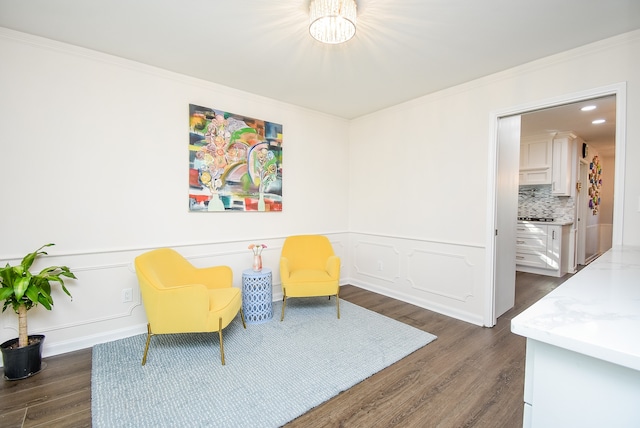 sitting room with dark hardwood / wood-style floors and crown molding