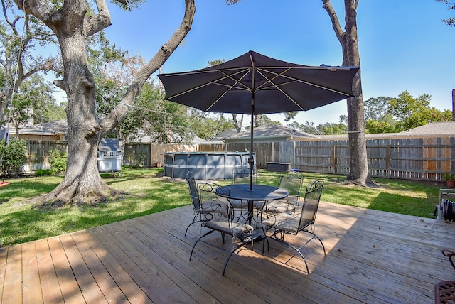 deck featuring a fenced in pool and a yard