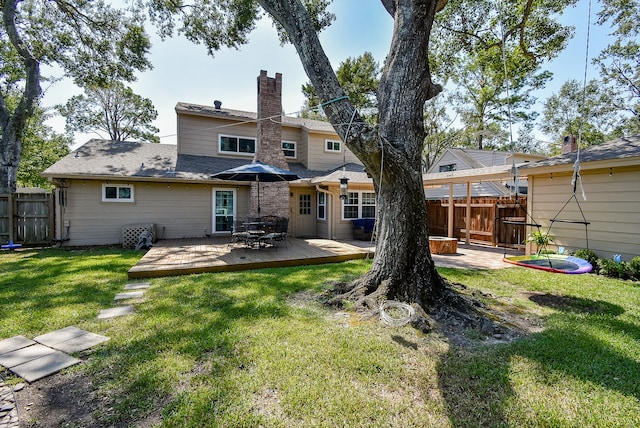 rear view of house featuring a yard and a deck