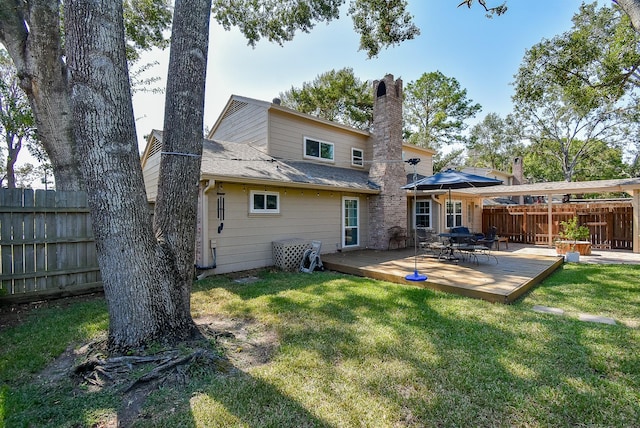 rear view of property featuring a yard and a wooden deck