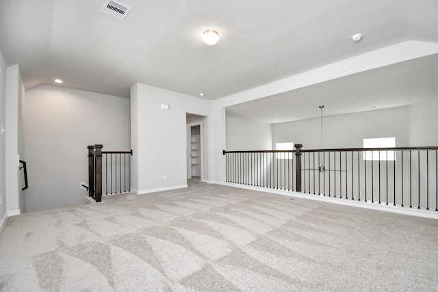 empty room featuring light carpet and lofted ceiling