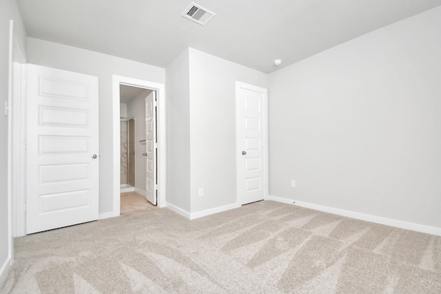 unfurnished bedroom featuring connected bathroom and light colored carpet