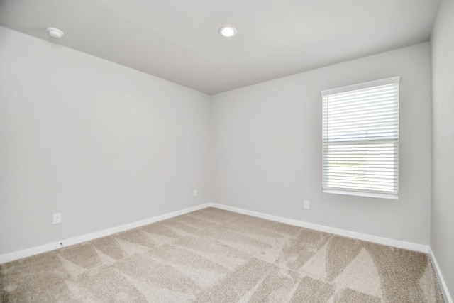 unfurnished room featuring light carpet