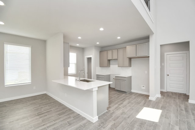 kitchen with sink, kitchen peninsula, and light wood-type flooring