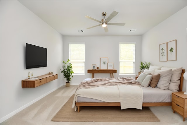 bedroom with ceiling fan and light carpet