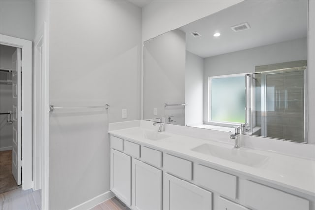 bathroom featuring vanity and a shower with door