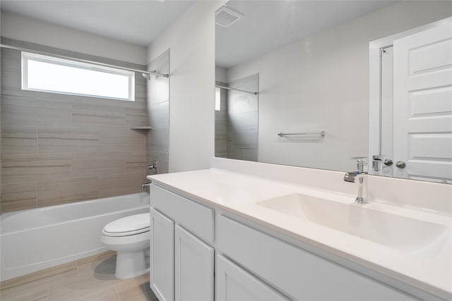 full bathroom with vanity, tiled shower / bath combo, and toilet