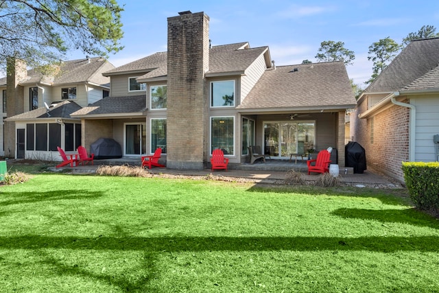 rear view of property featuring a patio area, a lawn, and ceiling fan