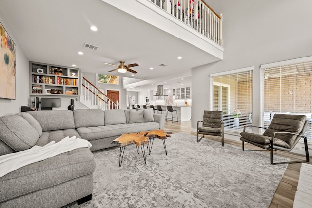 living room with light hardwood / wood-style flooring and ceiling fan