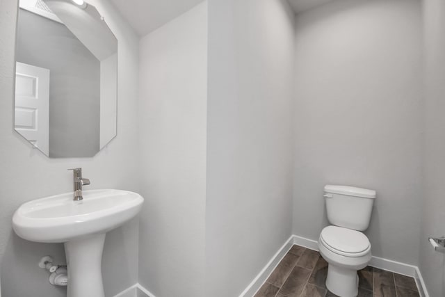 bathroom with sink, hardwood / wood-style flooring, and toilet